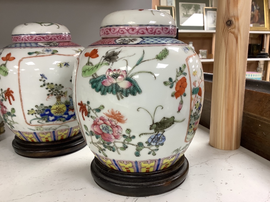 A pair of Chinese famille rose jars and covers, late 19/early 20th century, 15.5cm, on hardwood stands